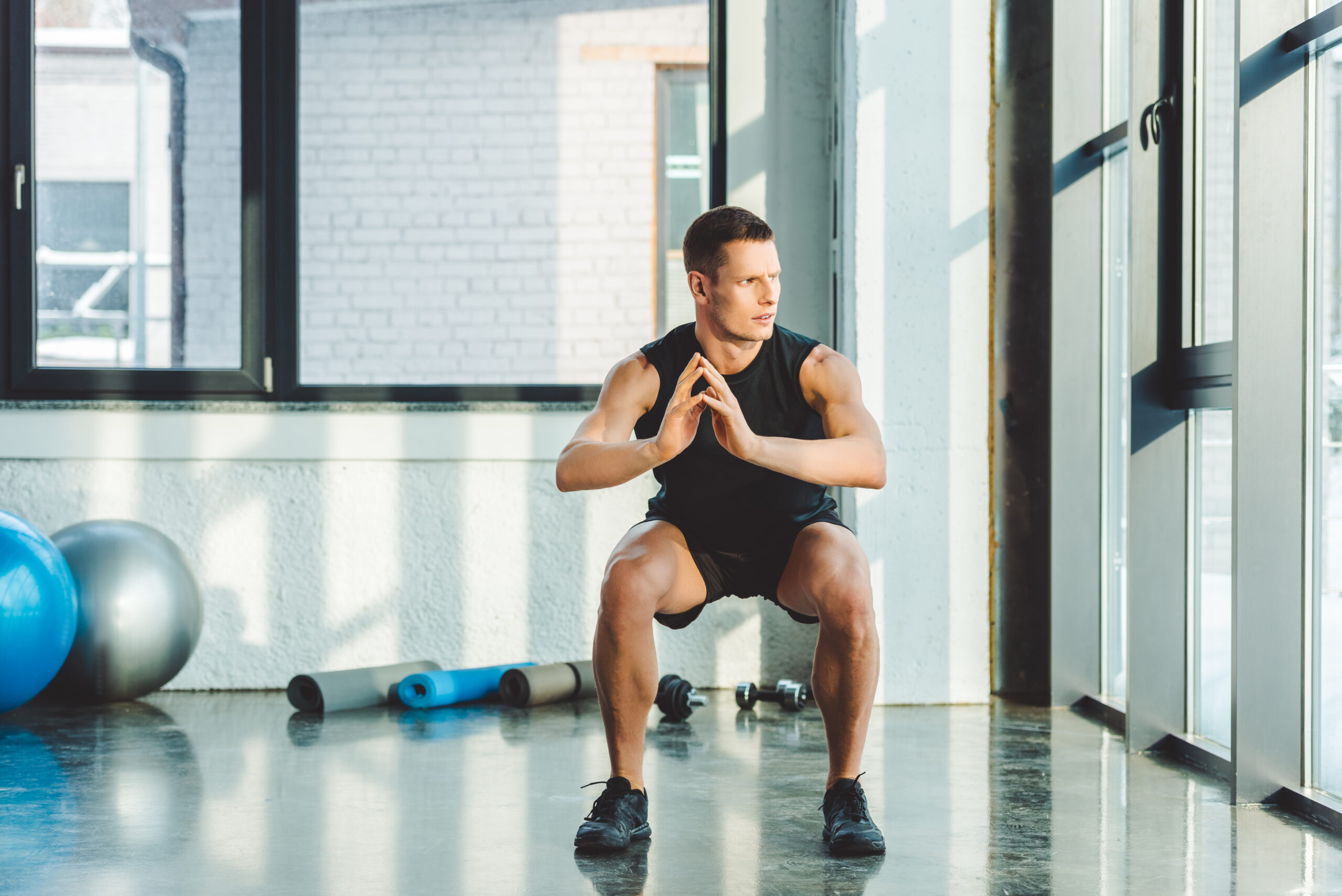 concentrated young sportsman working out in gym